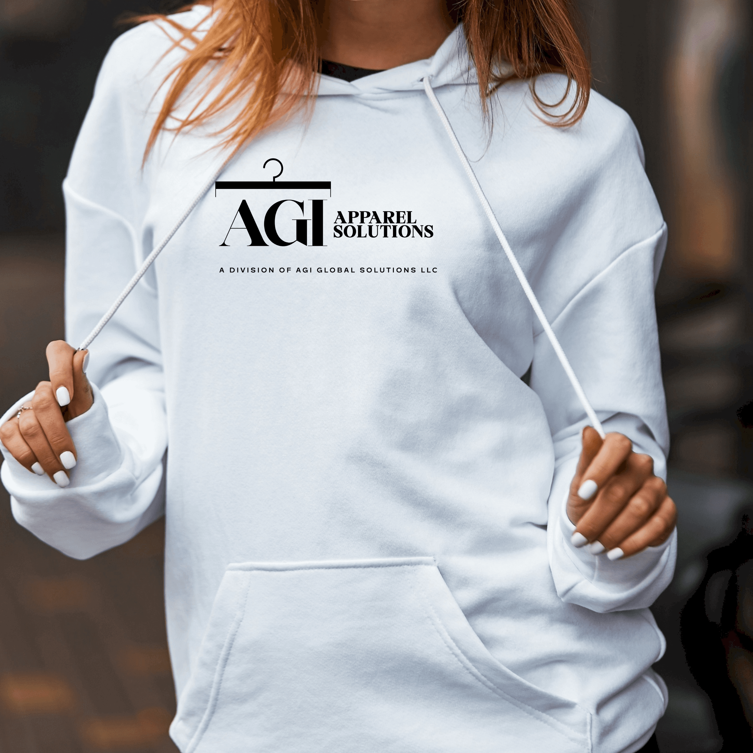 A person wearing a white hoodie featuring the black AGI Apparel Solutions logo.